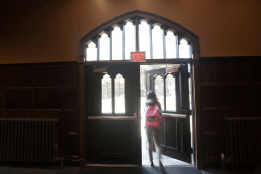 A student opening a door to exit a bulding