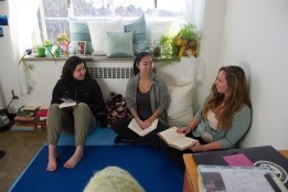 Three students sitting on the floor having a conversation