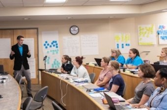 Michael Flynn at the front of a classroom in front of several Professional & Graduate Education students.