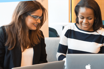 Master's students working together at their laptops