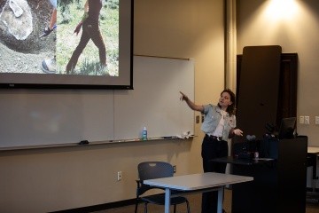 A student presents in front of a screen.