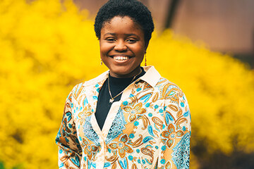 Oluwafadeyemi Testimony Akinkuolie-Ibidapo ’27 in front of yellow flowers. Photo by Max Wilhelm, 2025.
