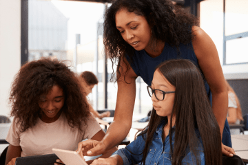 School age children in a classroom with their teacher
