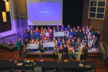 Participating Mount Holyoke faculty and students pose together on stage with AWS awards.