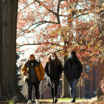 A group of three students walking on the Mount Holyoke campus in the fall