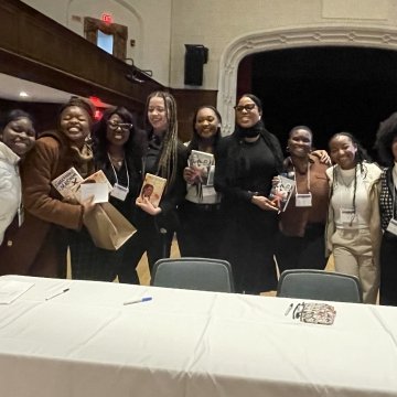 TOCLC attendees pose together with Ilyasah Shabazz and copies of her book.