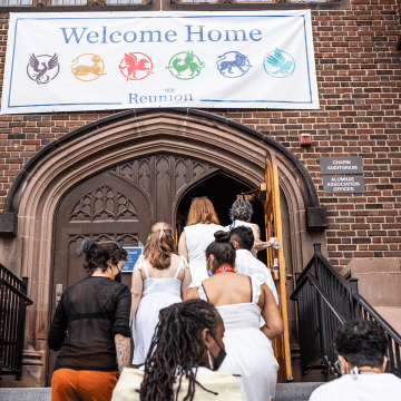 Alums walking up the steps to go into Chapin Auditorium, underneath the Welcome Home banner
