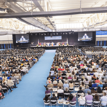 A view from the back of the room during Commencement 2023 -- the crowd and the stage