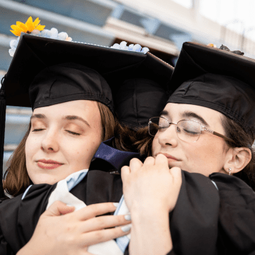 A three-way hug during Commencement 2023