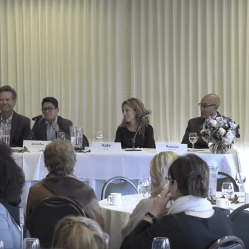 Faculty members sitting at a table in a panel
