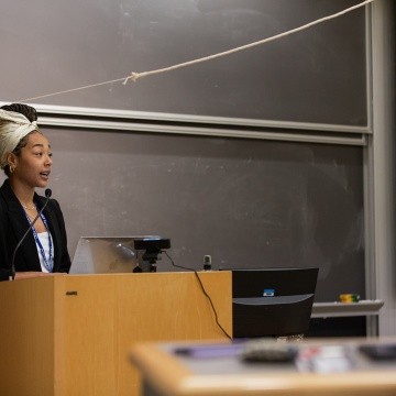 A student standing at a podium doing a presentation during LEAP Symposium 2022