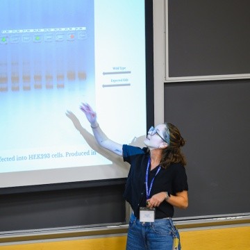 A student points out their presentation, LEAP Symposium 2025