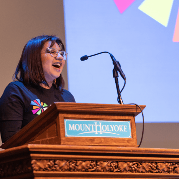 A student addresses the audience from the podium during the 2023 BOOM! Learning Symposium