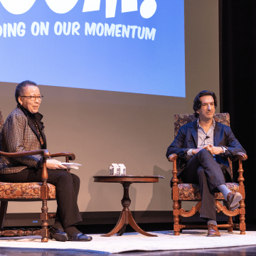 Dr. Beverly Daniel Tatum and Dr. Geoff Cohen seated onstage for the opening of the 2023 Boom! Learning Symposium