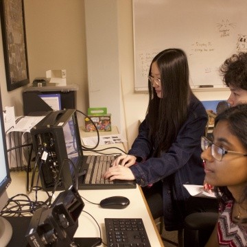 Psychology students studying data from eye tracking equipment