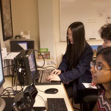 Psychology students studying data from eye tracking equipment