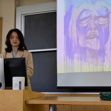 A student standing behind a podium while presenting during Senior Symposium 2023
