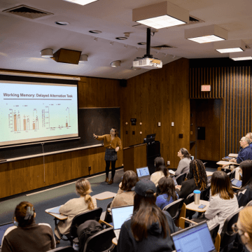 Presenter pointing at a screen presentation during Senior Symposium 2023