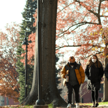 A group of three students walking on the Mount Holyoke campus in the fall