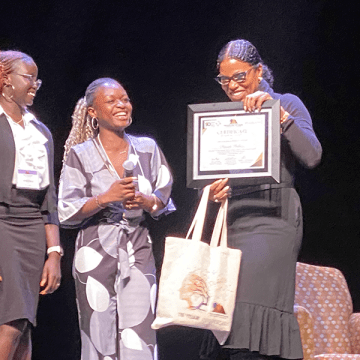 TOCLC attendees present Ilyasah Shabazz with a certificate.