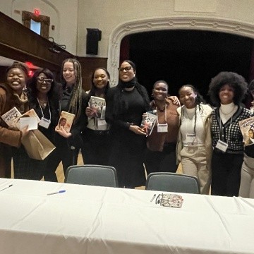 TOCLC attendees pose together with Ilyasah Shabazz and copies of her book.