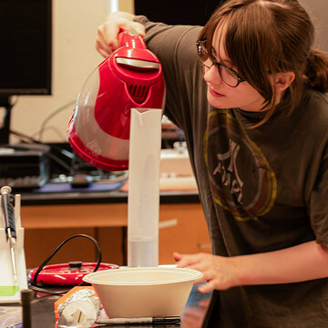 MHC student attending the QIC event pours the ingredients carefully.