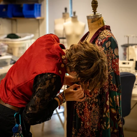 A student works on a costume for the Summer Theatre