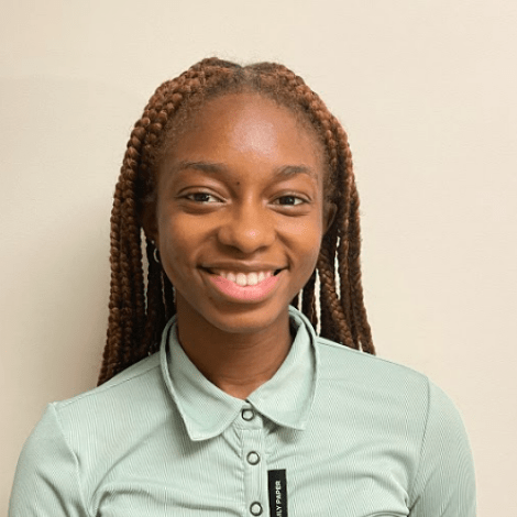 Sarah Bell ’25, wearing a light green button-down shirt and smiling