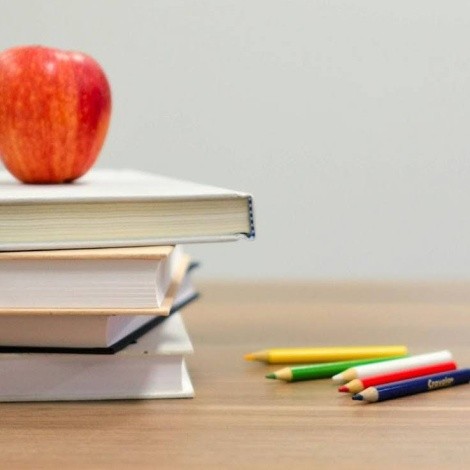 Teacher’s desk with books, blocks, colored pencils and an apple.