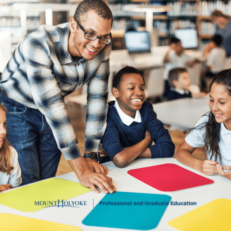 Students in a circle looking at colored pieces of paper.