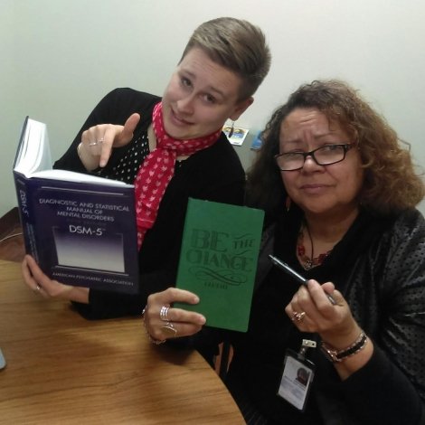 Megan Brookman with her supervisor holding a “Be the Change” sign. Image courtesy of Megan Brookman ‘14.