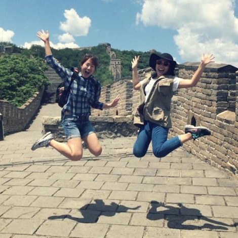Phuong Nguyen ’17, on right, jumping for joy in front of the Great Wall of China.