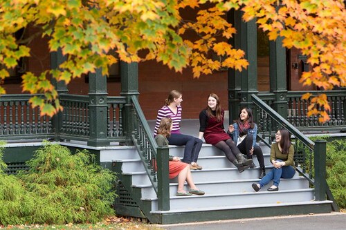 A group of Mount Holyoke College students sitting on some steps talking