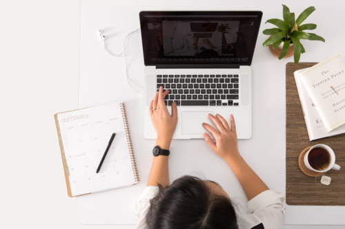 A student sitting at a desk using a laptop