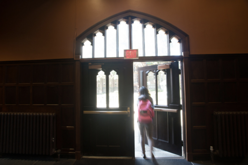 A student opening a door to exit a bulding