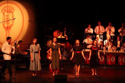 Four students singing on stage during a performance of the Big Broadcast