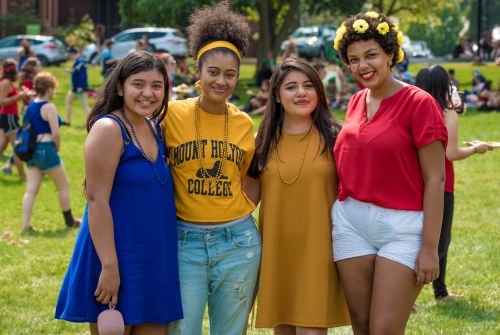 Four students dressed in class colors for Convocation