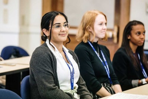 A classroom of students listening attentively during a LEAP Symposium presentation