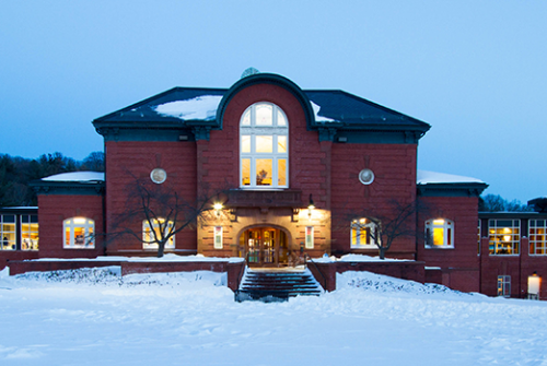 The front of Blanchard Hall lit up after a snowfall