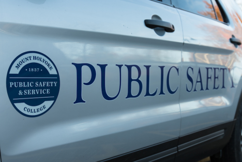 The side of a public safety and service vehicle, with a seal and the words "Public Safety" painted on the doors