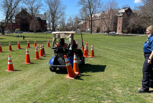 Students taking part in a drunk driving simulation while a public safety officer observes