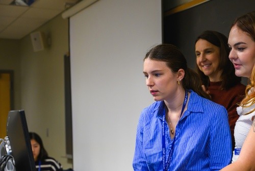 Students looking at a computer during the LEAP Symposium