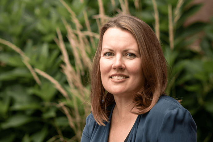 Trish Tanner seated outside near some plants