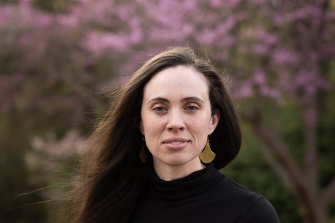 Caitlin Lambert ’09 in front of a pink flowering bush on the Mount Holyoke College campus.