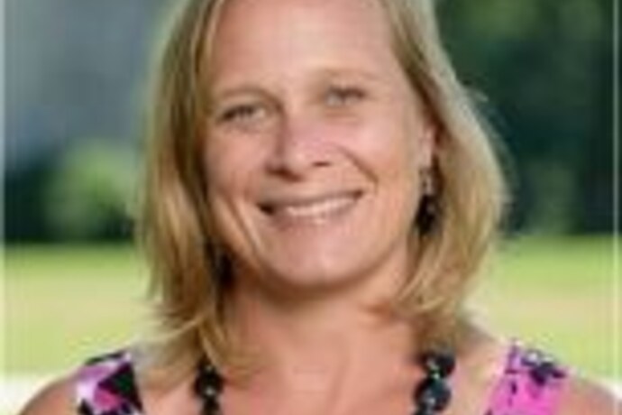 Amanda Mayfield, a woman with short blond hair wearing a black necklace and a pink and black top.