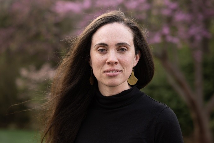 Caitlin Lambert ’09 in front of a pink flowering bush on the Mount Holyoke College campus.