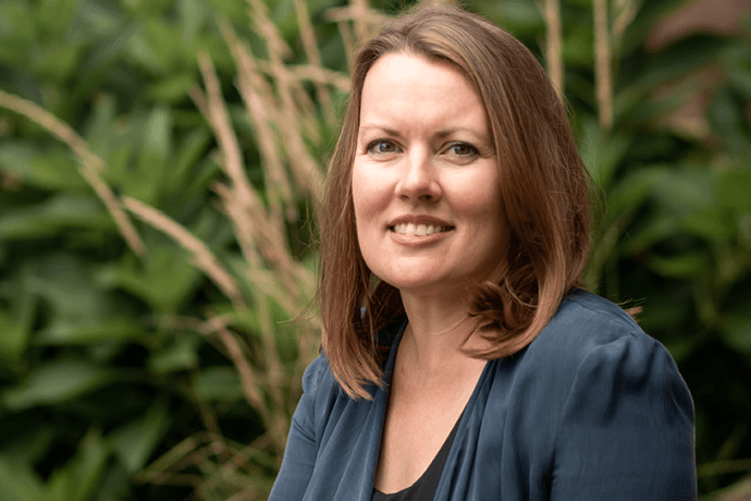 Trish Tanner seated outside near some plants