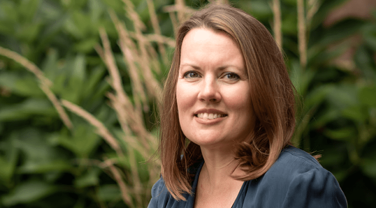 Trish Tanner seated outside near some plants