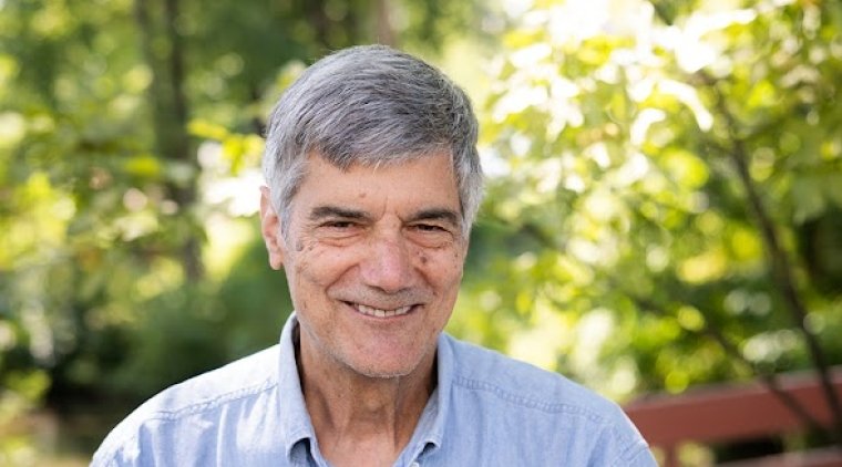 Vincent Ferlini - a white male wearing a blue shirt and smiling - on the Mount Holyoke campus in 2023.