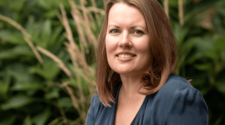 Trish Tanner seated outside near some plants